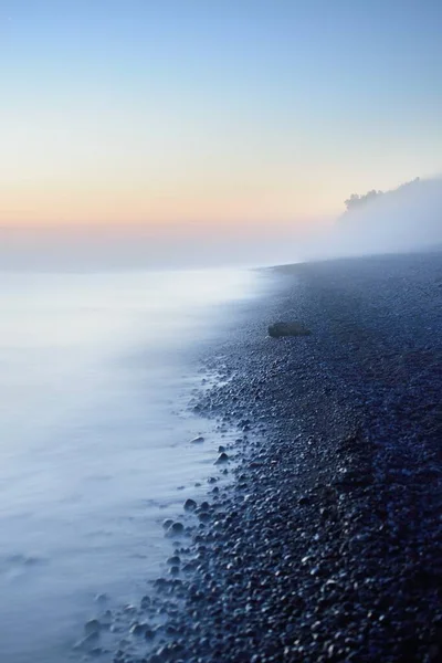 Baltık deniz kıyısının sisli manzarası nefes kesici panoramik. Parlak gökyüzü, gece yarısı güneşi, alacakaranlık. Resimli bir manzara var. Rüya gibi bir manzara. Saf doğa, çevre, ekoloji, turizm