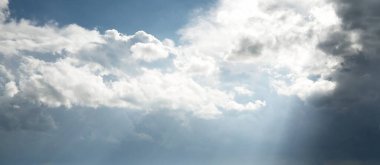 Destansı fırtına bulutları. Beyaz süslemeli günbatımı kümülüs bulutları. Yumuşak güneş ışığı. Açık mavi gökyüzü. Doğal desen, doku, arkaplan, duvar kağıdı, 3D, grafik kaynakları, tasarım, kopyalama alanı