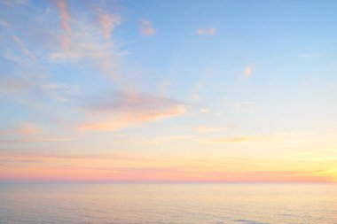 Gün batımında Baltık Denizi. Dramatik gökyüzü, mavi ve pembe parlayan bulutlar, yumuşak altın güneş ışığı, gece yarısı güneşi. Deniz manzarası, bulut manzarası, doğa. Panoramik görünüm