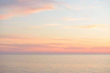 Gün batımında Baltık Denizi. Dramatik gökyüzü, mavi ve pembe parlayan bulutlar, yumuşak altın güneş ışığı, gece yarısı güneşi. Deniz manzarası, bulut manzarası, doğa. Panoramik görünüm