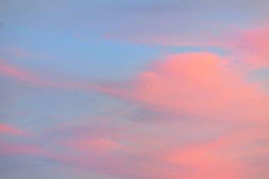 Açık mavi gökyüzü. Pembe parlayan, altın sirrus ve kümülüs bulutları fırtına üstüne, yumuşak güneş ışığı. Gün batımı bulutları. Meteoroloji, gece yarısı güneşi, cennet, huzur, grafik kaynakları, resimli panoramik manzara