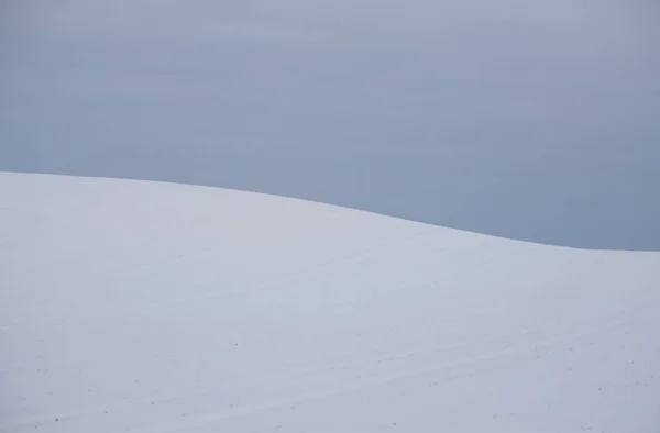 Panoramic view of snow-covered forest hills (agricultural field) under the dark storm sky. Concept winter landscape, ice desert. Nature, Christmas, remote places, off-road, climate change, weather