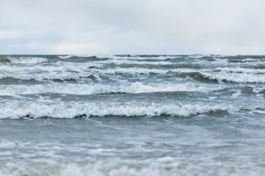 Kumlu bir sahilden (kum tepeleri) Baltık denizinin panoramik görüntüsü. Koyu bulutlu dramatik bir gökyüzü. Dalgalar, su sıçramaları. Idyllic deniz manzarası. Sıcak kış havası, iklim değişikliği, doğa. Danimarka