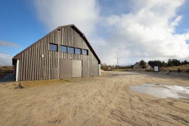 Baltık Denizi 'nin kumlu kıyısındaki küçük bir köyde modern ahşap depo binası. Jurmalciems, Letonya. Mimarlık, endüstri, balıkçılık, tarım ve gıda üretimi, yerel işletme kavramları. Kırsal alan
