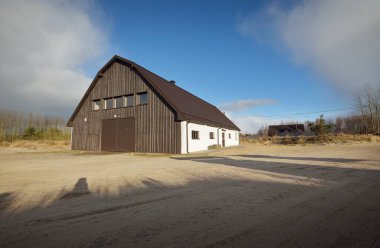 Baltık Denizi 'nin kumlu kıyısındaki küçük bir köyde modern ahşap depo binası. Jurmalciems, Letonya. Mimarlık, endüstri, balıkçılık, tarım ve gıda üretimi, yerel işletme kavramları. Kırsal alan
