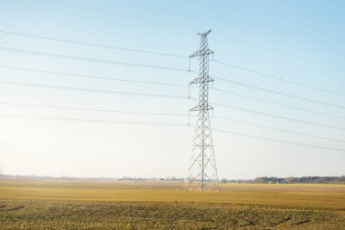 Elektrik hattı açık mavi gökyüzüne karşı, yakın plan. Şehir manzarası kavramı. Enerji, enerji üretimi, özel ekipman, endüstri, çevresel hasar, ekoloji, altyapı, ormanların tahrip