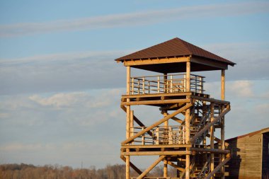 Modern ahşap merdiven (tahta kaldırım), göl bölgesinin yakınındaki kuş izleme kulesi. Baharın başında. Doğa, çevre, eko-turizm, eğlence, ekolojik rezerv, milli park, ornitoloji, bilim