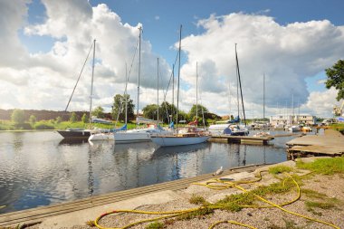 Zarif ve modern yelkenliler güneşli bir yaz gününde bir rıhtıma demirlemiş ve yat limanında karada duruyorlardı. Tatiller, ulaşım, spor, eğlence, turizm, seyahat, balıkçılık, liman hizmeti