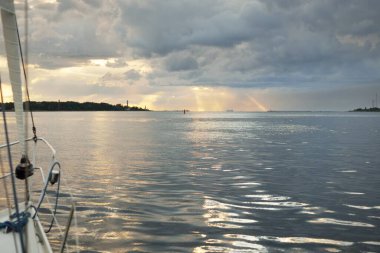 Fırtınadan sonra Baltık Denizi, yelkenli tekneden panoramik manzara. Dramatik gün batımı gökyüzü. Parlayan bulutlar, altın güneş ışığı. Idyllic deniz manzarası. Doğa, gezi, seyahat yerleri