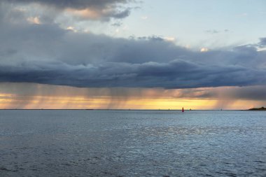 Fırtınadan sonra Baltık Denizi, yelkenli tekneden panoramik manzara. Dramatik gün batımı gökyüzü. Parlayan bulutlar, altın güneş ışığı. Idyllic deniz manzarası. Doğa, gezi, seyahat yerleri