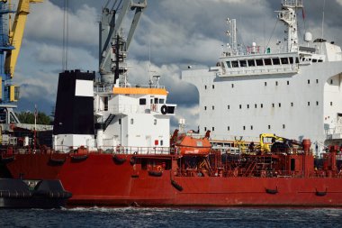 Kargo gemileri iskele terminaline yükleniyor. Vinçler arka planda. Baltık Denizi. Bunkering, akaryakıt ve enerji üretimi, arz, teknoloji, lojistik, hizmet, sanayi, ticaret