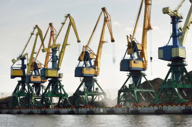 Riga, Letonya 'daki modern kömür terminali. Vinçler yakın plan. Baltık Denizi. Nakliye, lojistik, küresel iletişim, ekonomi, iş, endüstri, tedarik, özel ekipman. Şehir manzarası