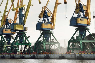 Riga, Letonya 'daki modern kömür terminali. Vinçler yakın plan. Baltık Denizi. Nakliye, lojistik, küresel iletişim, ekonomi, iş, endüstri, tedarik, özel ekipman. Şehir manzarası