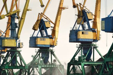 Riga, Letonya 'daki modern kömür terminali. Vinçler yakın plan. Baltık Denizi. Nakliye, lojistik, küresel iletişim, ekonomi, iş, endüstri, tedarik, özel ekipman. Şehir manzarası