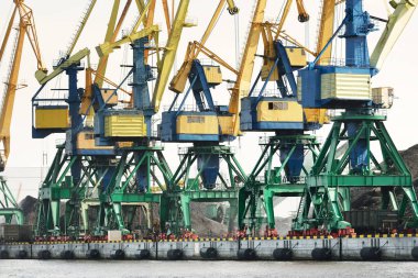 Riga, Letonya 'daki modern kömür terminali. Vinçler yakın plan. Baltık Denizi. Nakliye, lojistik, küresel iletişim, ekonomi, iş, endüstri, tedarik, özel ekipman. Şehir manzarası