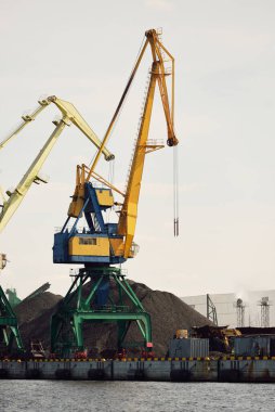 Riga, Letonya 'daki modern kömür terminali. Vinçler yakın plan. Baltık Denizi. Nakliye, lojistik, küresel iletişim, ekonomi, iş, endüstri, tedarik, özel ekipman. Şehir manzarası