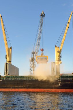 Liman terminalinde vinçleri yükleyen büyük bir yük gemisi (179 metre uzunluğunda). Baltık Denizi. Nakliye, lojistik, küresel iletişim, ekonomi, ticaret, sanayi, arz