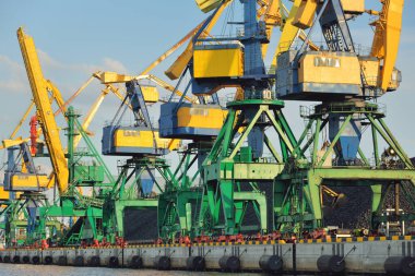 Riga, Letonya 'daki modern kömür terminali. Vinçler yakın plan. Baltık Denizi. Yük taşımacılığı, lojistik, küresel iletişim, ekonomi, ticaret, sanayi, arz, özel ekipman