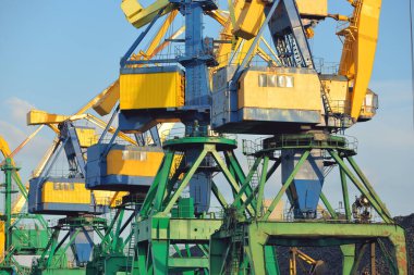 Riga, Letonya 'daki modern kömür terminali. Vinçler yakın plan. Baltık Denizi. Yük taşımacılığı, lojistik, küresel iletişim, ekonomi, ticaret, sanayi, arz, özel ekipman