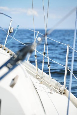 Günbatımında Baltık Denizi 'nde yelkenli yelkenli yelkenli. Kokpitten görüntü. Tekne kenarı korkulukları yakın plan. Ulaşım, seyahat, gezi, spor, eğlence, boş zaman aktivitesi, yelkenli yarışı
