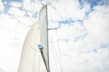 Günbatımında Baltık Denizi 'nde yelkenli yelkenli yelkenli. Kokpitten direğe ve yelkenlere bakın. Dramatik bir gökyüzü. Ulaşım, seyahat, gezi, spor, eğlence, boş zaman aktivitesi, yelkenli yarışı