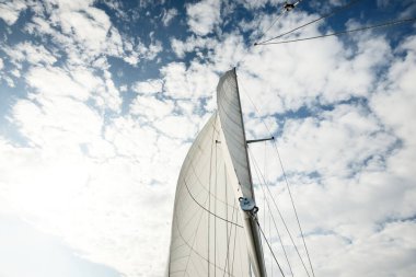 Günbatımında Baltık Denizi 'nde yelkenli yelkenli yelkenli. Kokpitten direğe ve yelkenlere bakın. Dramatik bir gökyüzü. Ulaşım, seyahat, gezi, spor, eğlence, boş zaman aktivitesi, yelkenli yarışı