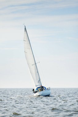 Açık denizde yelkenli yelkenli yelkenli. Gökyüzü açık, bulutlu. Yelkenlinin manzarası. Ulaşım, seyahat, spor, eğlence, boş zaman aktivitesi, yarış, yelkenli yarışı. Panorama, boşluğu kopyala