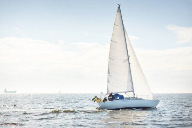 Açık denizde yelkenli yelkenli yelkenli. Gökyüzü açık, bulutlu. Yelkenlinin manzarası. Ulaşım, seyahat, spor, eğlence, boş zaman aktivitesi, yarış, yelkenli yarışı. Panorama, boşluğu kopyala