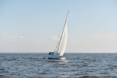 Açık denizde yelkenli yelkenli yelkenli. Gökyüzü açık, bulutlu. Yelkenlinin manzarası. Ulaşım, seyahat, spor, eğlence, boş zaman aktivitesi, yarış, yelkenli yarışı. Panorama, boşluğu kopyala