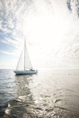 Açık denizde yelkenli yelkenli yelkenli. Gökyüzü açık, bulutlu. Yelkenlinin manzarası. Ulaşım, seyahat, spor, eğlence, boş zaman aktivitesi, yarış, yelkenli yarışı. Panorama, boşluğu kopyala