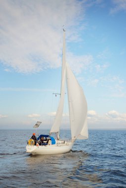Açık denizde yelkenli yelkenli yelkenli. Gökyüzü açık, bulutlu. Yelkenlinin manzarası. Ulaşım, seyahat, spor, eğlence, boş zaman aktivitesi, yarış, yelkenli yarışı. Panorama, boşluğu kopyala