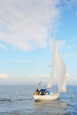 Açık denizde yelkenli yelkenli yelkenli. Gökyüzü açık, bulutlu. Yelkenlinin manzarası. Ulaşım, seyahat, spor, eğlence, boş zaman aktivitesi, yarış, yelkenli yarışı. Panorama, boşluğu kopyala