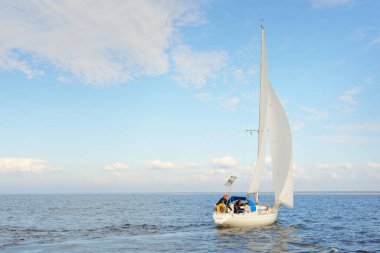 Açık denizde yelkenli yelkenli yelkenli. Gökyüzü açık, bulutlu. Yelkenlinin manzarası. Ulaşım, seyahat, spor, eğlence, boş zaman aktivitesi, yarış, yelkenli yarışı. Panorama, boşluğu kopyala