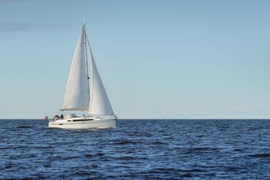 Baltık Denizi 'nde yelkenli bir yat. Gün batımı. Fırtınadan sonra dramatik bir gökyüzü, yumuşak güneş ışığı. Ulaşım, seyahat, seyahat, yat yarışı, spor, eğlence, eğlence, eğlence, yaşam tarzı, aile.
