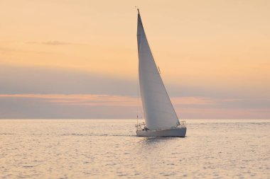 Günbatımında Baltık Denizi 'nde yelkenli yelkenli yelkenli. Fırtınadan sonra gökyüzü açık, altın güneş ışığı. Ulaşım, seyahat, gezi, spor, eğlence, boş zaman aktivitesi, yarış, yelkenli yarışı