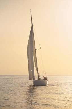 Günbatımında Baltık Denizi 'nde yelkenli yelkenli yelkenli. Fırtınadan sonra gökyüzü açık, altın güneş ışığı. Ulaşım, seyahat, gezi, spor, eğlence, boş zaman aktivitesi, yarış, yelkenli yarışı