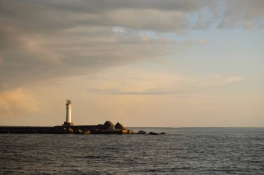 Fırtınadan sonra Baltık Denizi, yelkenli tekneden panoramik manzara. Deniz feneri. Dramatik gün batımı gökyüzü. Parlayan bulutlar, altın güneş ışığı. Idyllic deniz manzarası. Doğa, gezi, seyahat yerleri