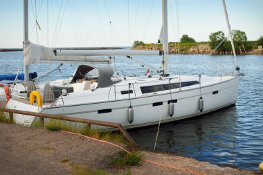 Günbatımında limanda bir rıhtıma demirlenmiş modern beyaz şalopeli yat. Panoramik manzara. Akdeniz 'de. Kiralık, gezici, eğlence, eğlence, eğlence, spor, yelkenli yarışı için özel bir gemi.