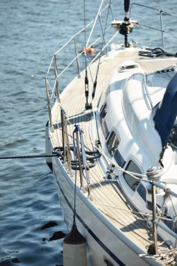 Limandaki bir rıhtıma demirlenmiş modern bir yat. Tahta meşe güvertesi, direği ve yelkenleri yukarıdan görüyor. Akdeniz 'de. Kiralık, gezici, eğlence, eğlence, eğlence, spor, yelkenli yarışı için özel bir gemi.