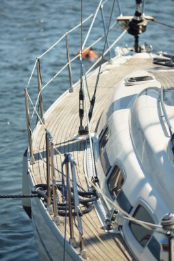 Limandaki bir rıhtıma demirlenmiş modern bir yat. Tahta meşe güvertesi, direği ve yelkenleri yukarıdan görüyor. Akdeniz 'de. Kiralık, gezici, eğlence, eğlence, eğlence, spor, yelkenli yarışı için özel bir gemi.