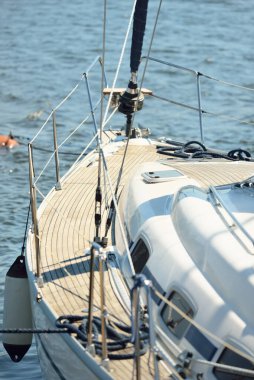 Limandaki bir rıhtıma demirlenmiş modern bir yat. Tahta meşe güvertesi, direği ve yelkenleri yukarıdan görüyor. Akdeniz 'de. Kiralık, gezici, eğlence, eğlence, eğlence, spor, yelkenli yarışı için özel bir gemi.