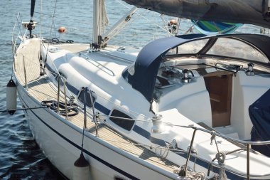 Limandaki bir rıhtıma demirlenmiş modern bir yat. Tahta meşe güvertesi, direği ve yelkenleri yukarıdan görüyor. Akdeniz 'de. Kiralık, gezici, eğlence, eğlence, eğlence, spor, yelkenli yarışı için özel bir gemi.