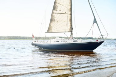 Kumlu kıyıya demirli mavi şalopalı yat (plaj). İsveç 'te, Avrupa' da. Doğa, yaz tatilleri, eğlence, gezi, spor, ulaşım, kiralık özel gemi.