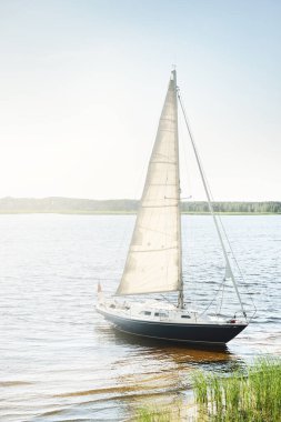 Kumlu kıyıya demirli mavi şalopeli yat (kumsalda otlarla kaplanmış). İsveç 'te, Avrupa' da. Doğa, yaz tatilleri, eğlence, gezi, spor, ulaşım. Hava görünümü