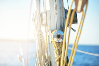 Açık bir günde beyaz yelkenli tekneyle denize açılmak. Güverteden direğe kadar bir manzara. Ekipmanlar, ipler, yakın çekim. Ulaşım, seyahat, gezi, eğlence, eğlence, eğlence, yat yarışı.
