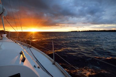 Beyaz yat gün batımında açık denizde yüzüyor. Güverteden pruvaya bir manzara, direk, yelkenler. Destansı bulut manzarası. Fırtınadan sonra parlayan altın bulutlarla dramatik bir gökyüzü. Yarış, spor, eğlence aktivitesi