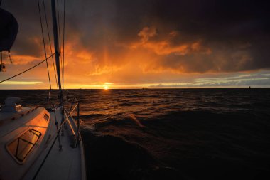 Beyaz yat gün batımında açık denizde yüzüyor. Güverteden pruvaya bir manzara, direk, yelkenler. Destansı bulut manzarası. Fırtınadan sonra parlayan altın bulutlarla dramatik bir gökyüzü. Yarış, spor, eğlence aktivitesi
