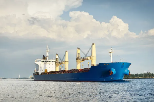 クレーン付きの大型貨物船は日没時に港を出発します バルト海 劇的な嵐の空 貨物輸送 グローバル通信 ビジネス — ストック写真