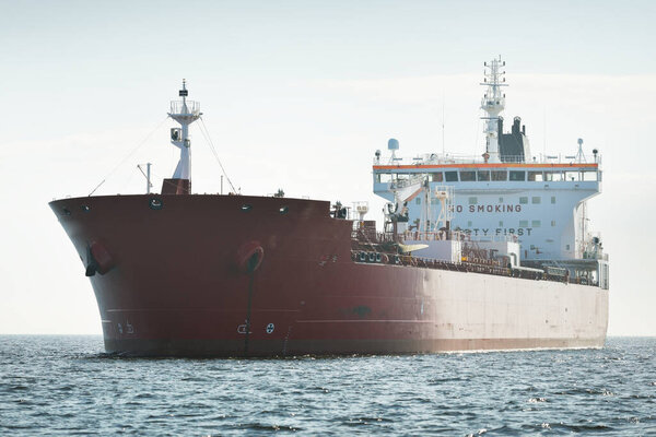 Large red cargo ship (oil chemical tanker, 184  meters length) sailing in the Baltic sea. Freight transportation, logistics, global communications, economy, industry, supply, environment