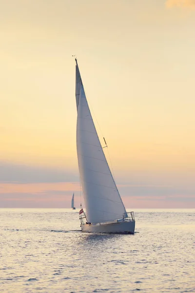 白いスループは 日没時にバルト海を航行するヨットを操縦しました 嵐の後に澄んだ空 黄金の太陽 クルーズ スポーツ レクリエーション レジャー活動 レース レガッタ — ストック写真